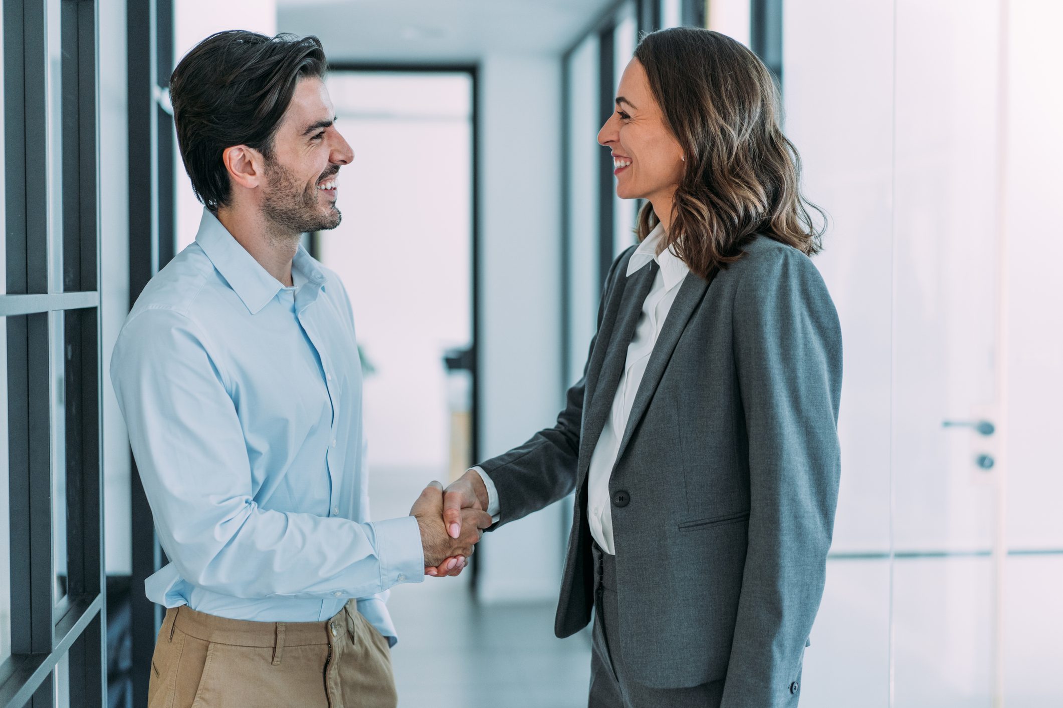 Business people shaking hands in the office. Business persons handshaking during a meeting in modern office.